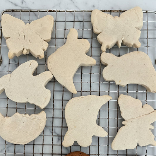 Baking tray with butterfly-shaped cookies and chocolate cookies on a cooling rack.