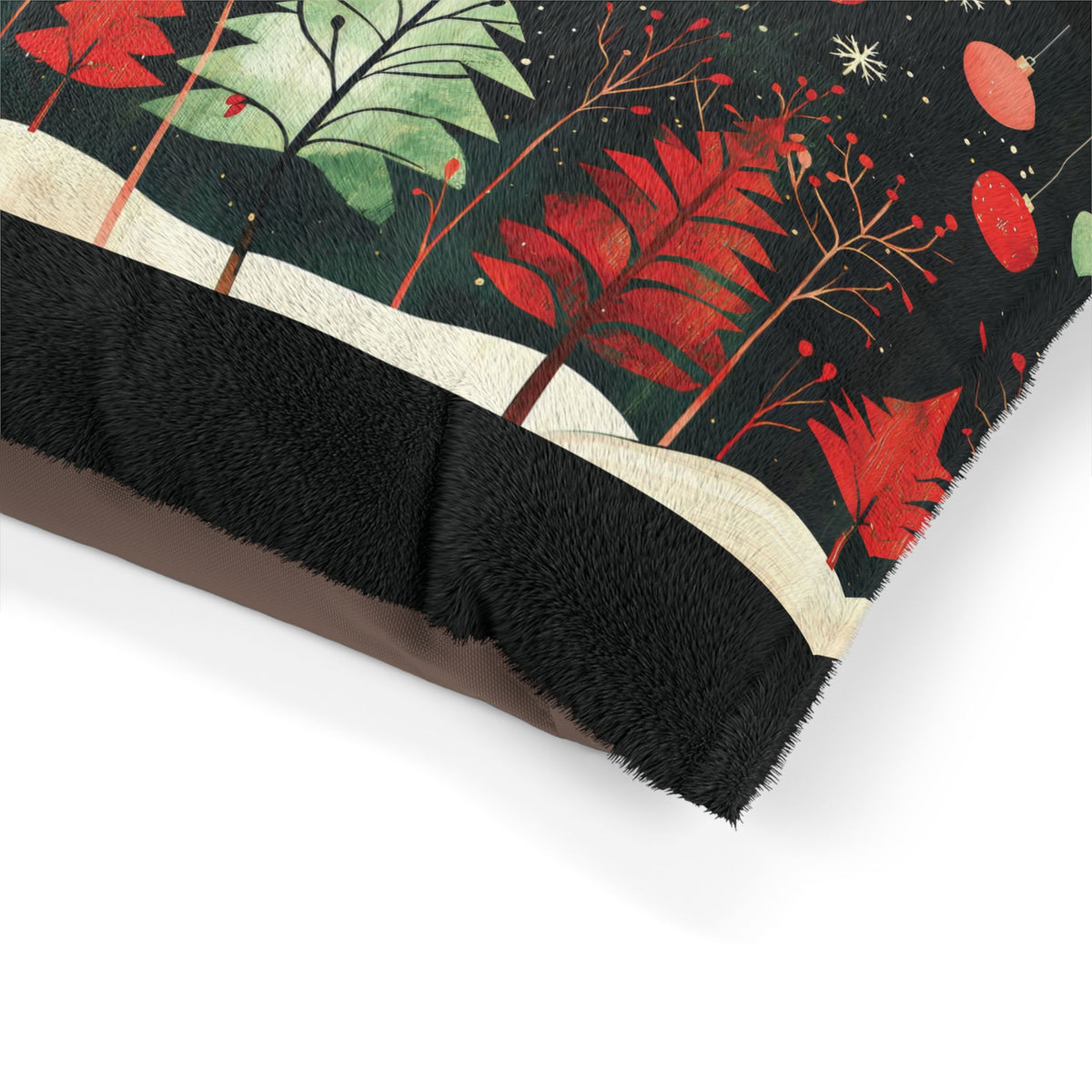 A close-up of a plush throw blanket with a black faux-fur border and a festive winter forest print featuring red and green trees on a dark background.