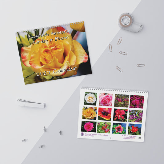 A spiral-bound 2027 garden calendar titled 'Swedish Seasons Garden in Bloom' is shown in a styled flat-lay arrangement on a light gray surface. The cover features a large yellow rose, and the interior page displays a 3x3 grid of colorful flower photographs.