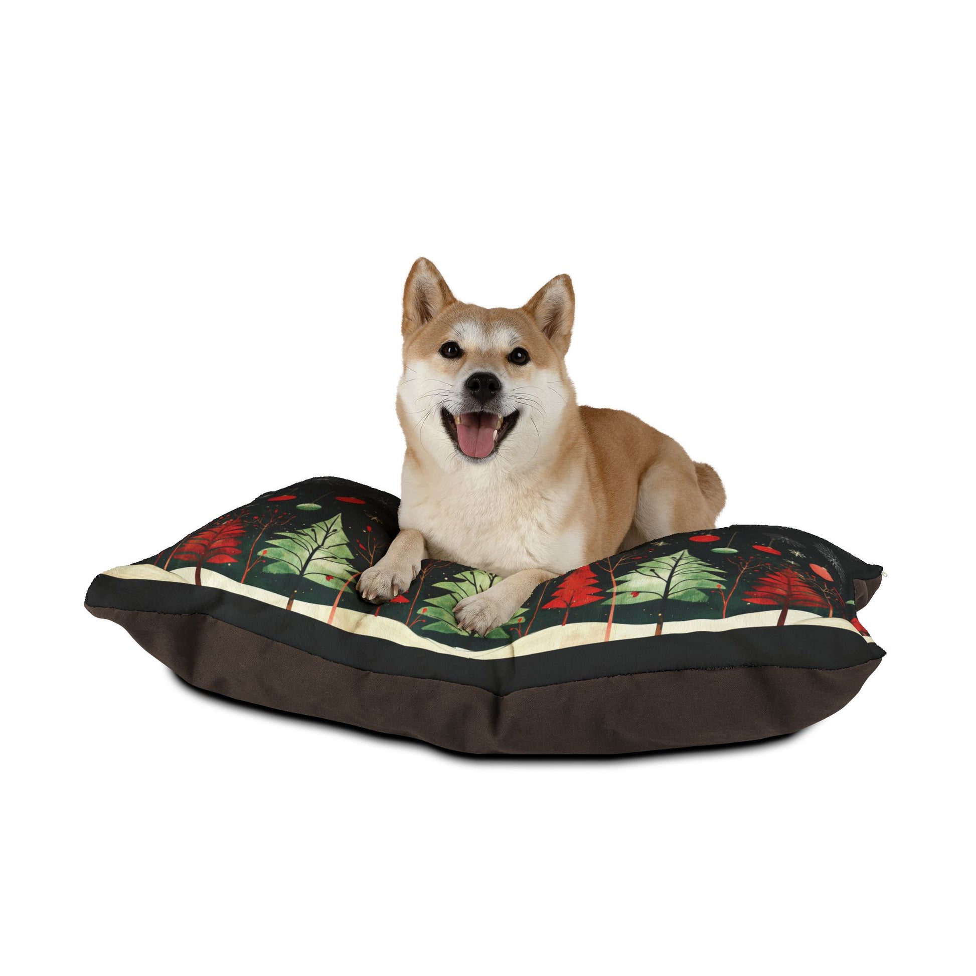 A tan Shiba Inu dog lies on a rectangular dog bed with a dark brown base and a forest pattern of green trees and red leaves on top, photographed against a solid white background.
