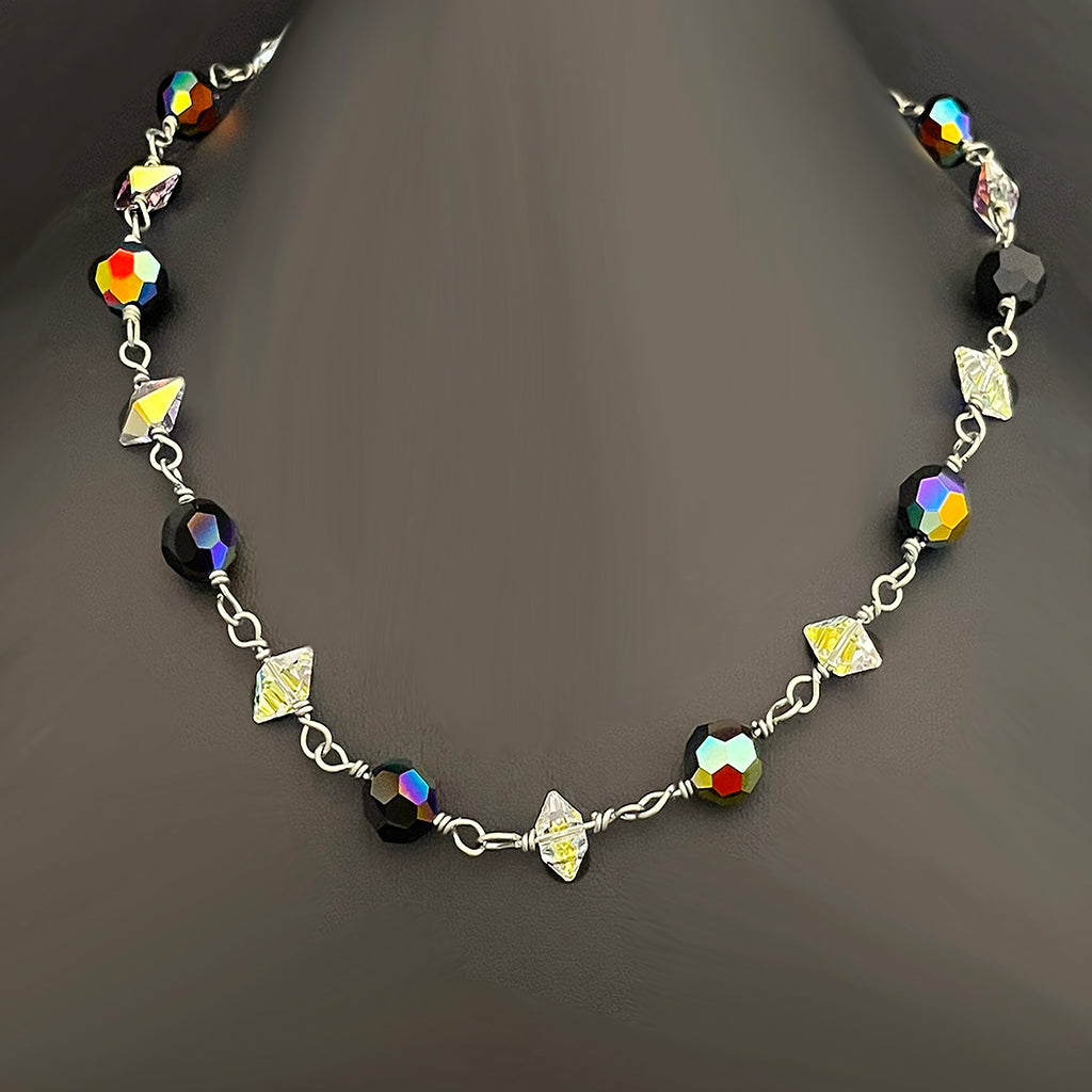 Necklace with colorful beads and silver chain on a dark background