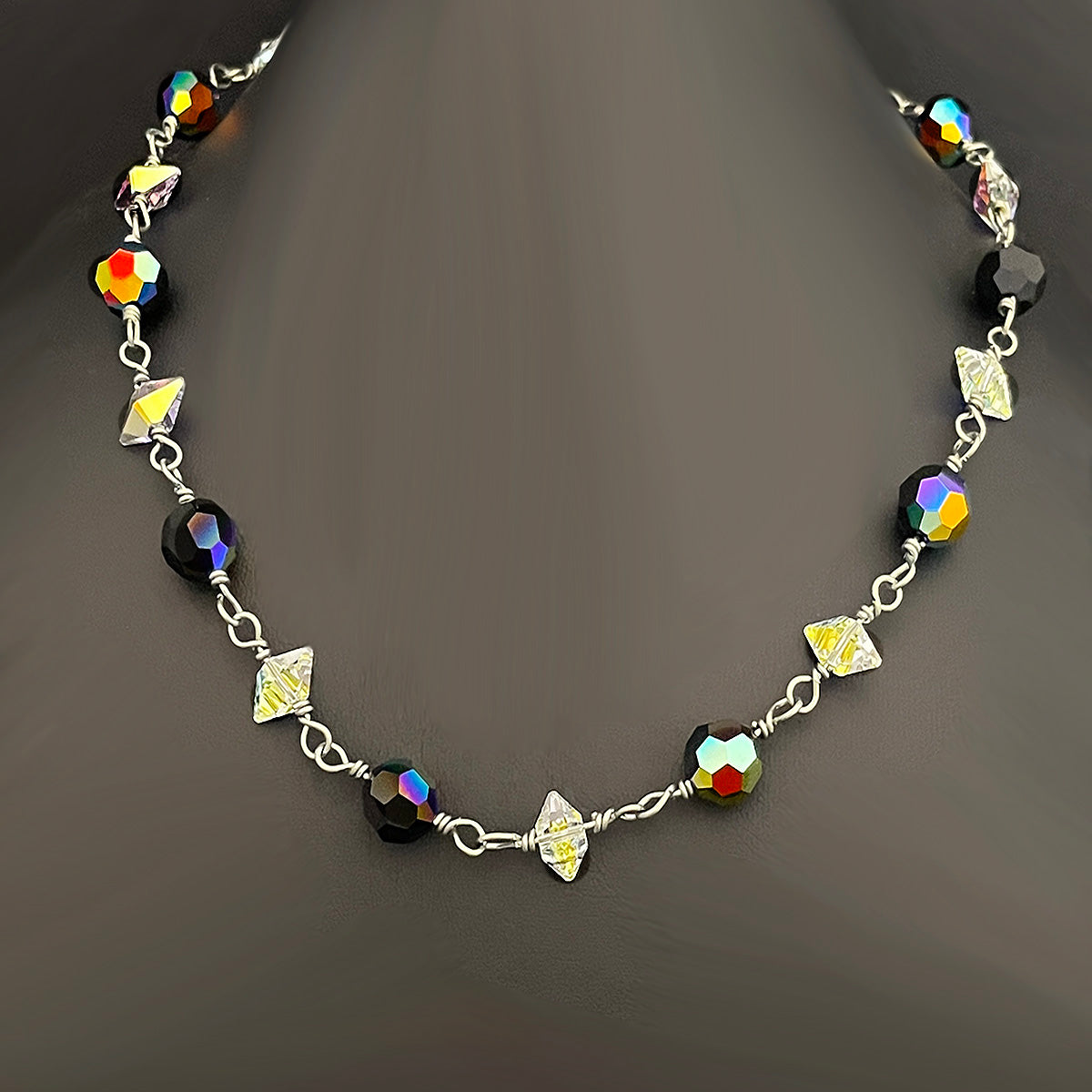 Necklace with colorful beads and silver chain on a dark background