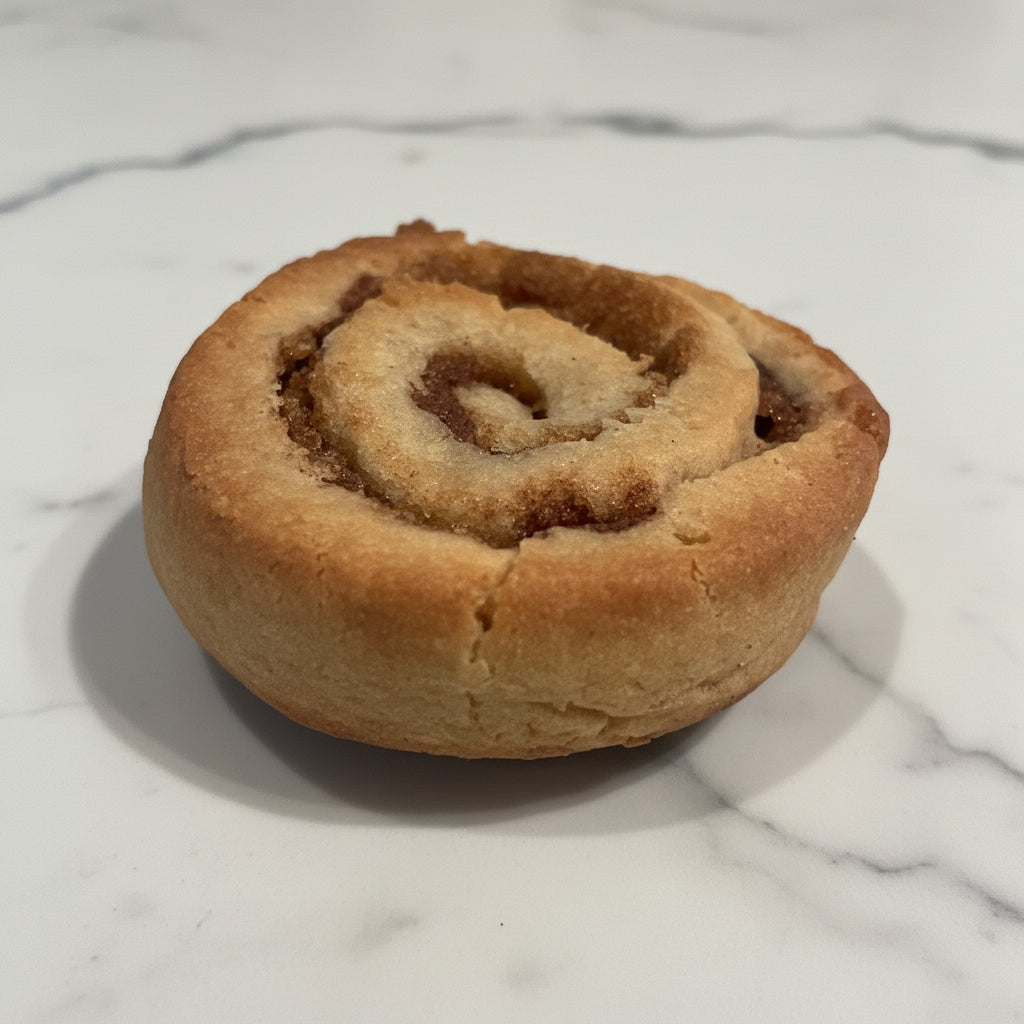 Cinnamon roll on a cooling rack with a textured wall background