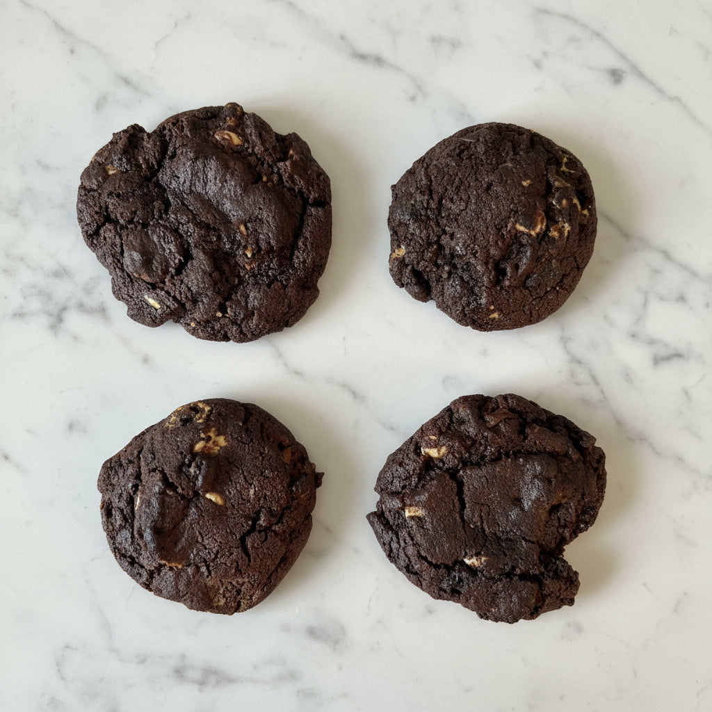 Four chocolate cookies on marble counter