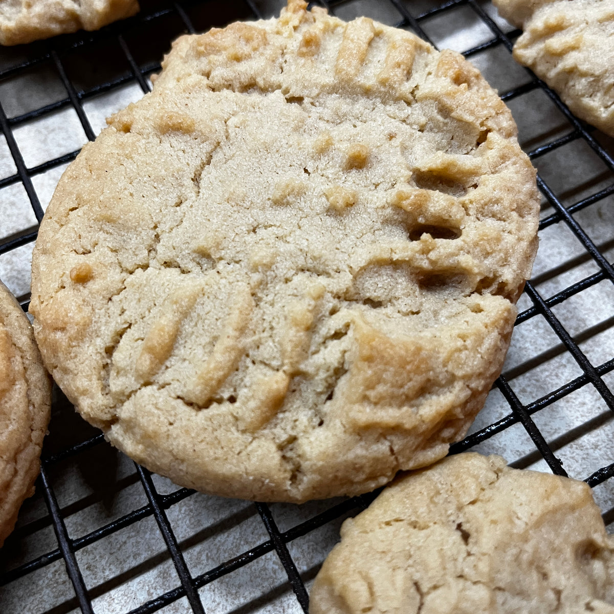 Cookies on a cooling rack with a close-up of a single cookie.
