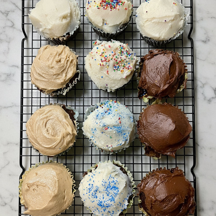 Assorted cupcakes with different frosting flavors on a baking tray.