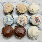 Assorted cupcakes with different frosting flavors on a baking tray.